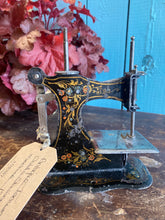 Antique German pressed tin child’s sewing machine.
