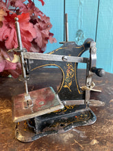 Antique German pressed tin child’s sewing machine.