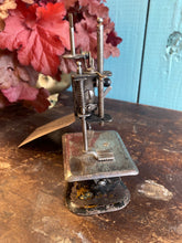 Antique German pressed tin child’s sewing machine.