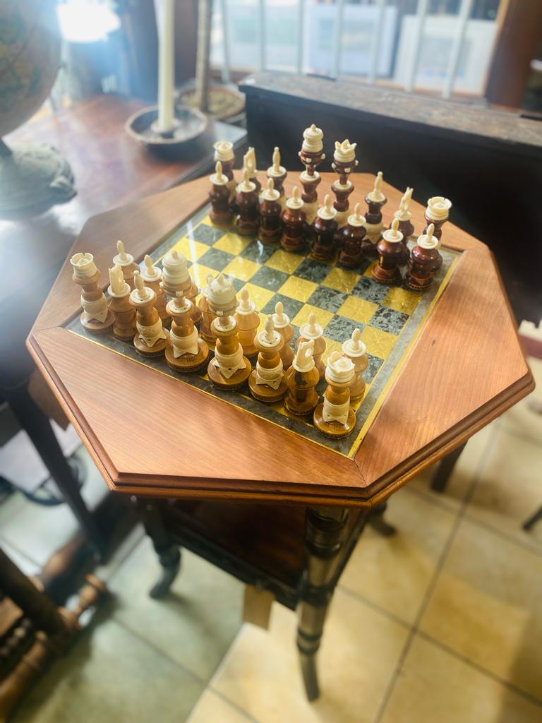 Antique chess able glass top over gold leaf squares.